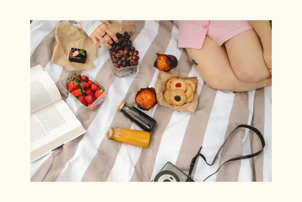 photo d'une fille faisant un pic nique avec jus de fruits, fruits, muffin. photo utilisé pour la page mon compte Lamievégé